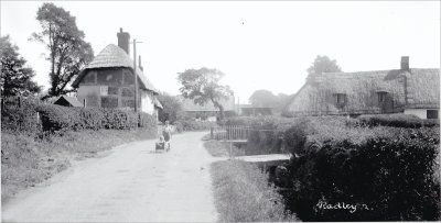 B&W photo of road through what is now Lower Radley showing Spinney's Cottage on the left and what is now 46 Lower Radley